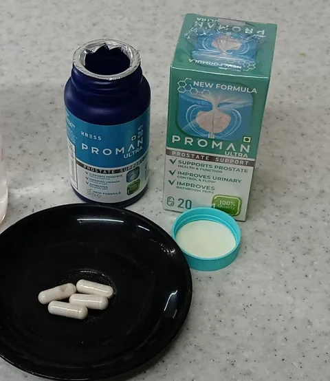 Proman Ultra capsules on a black plate next to the open bottle and box